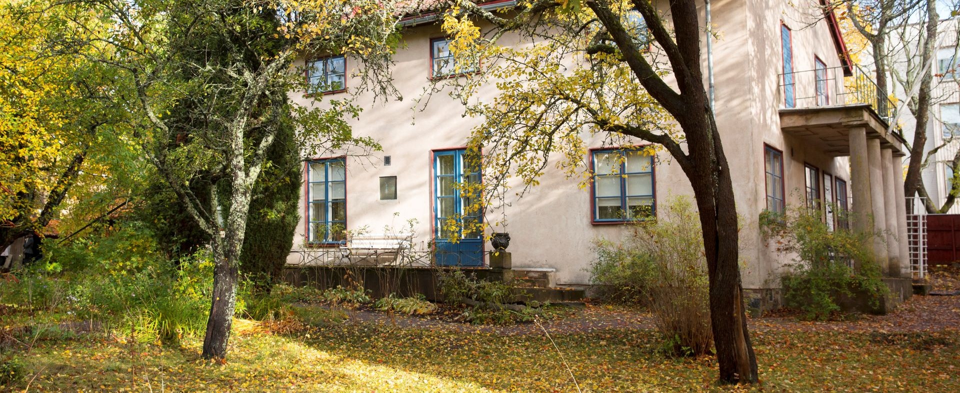 Casa Haartman, ett rappat stenhus i en lummig trädgård.