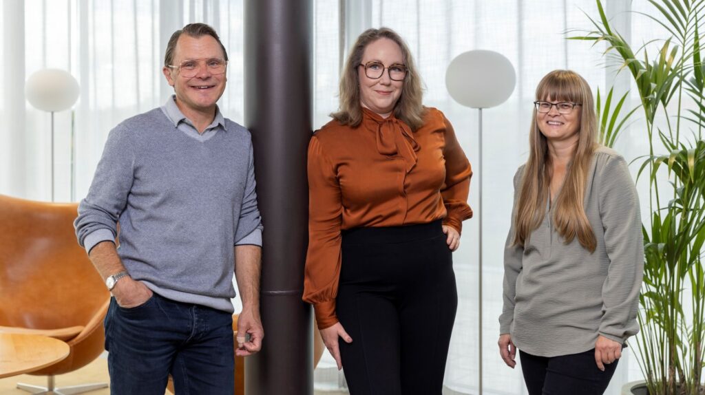 Katsomukset-bloggens svenskspråkiga redaktionsråd på tre personer, en man och två kvinnor. Mannen har glasögon och grå tröja. Kvinnan i mitten har en orange blus. Kvinnan till höger har långt ljust hår och en ljusgrön tunika.