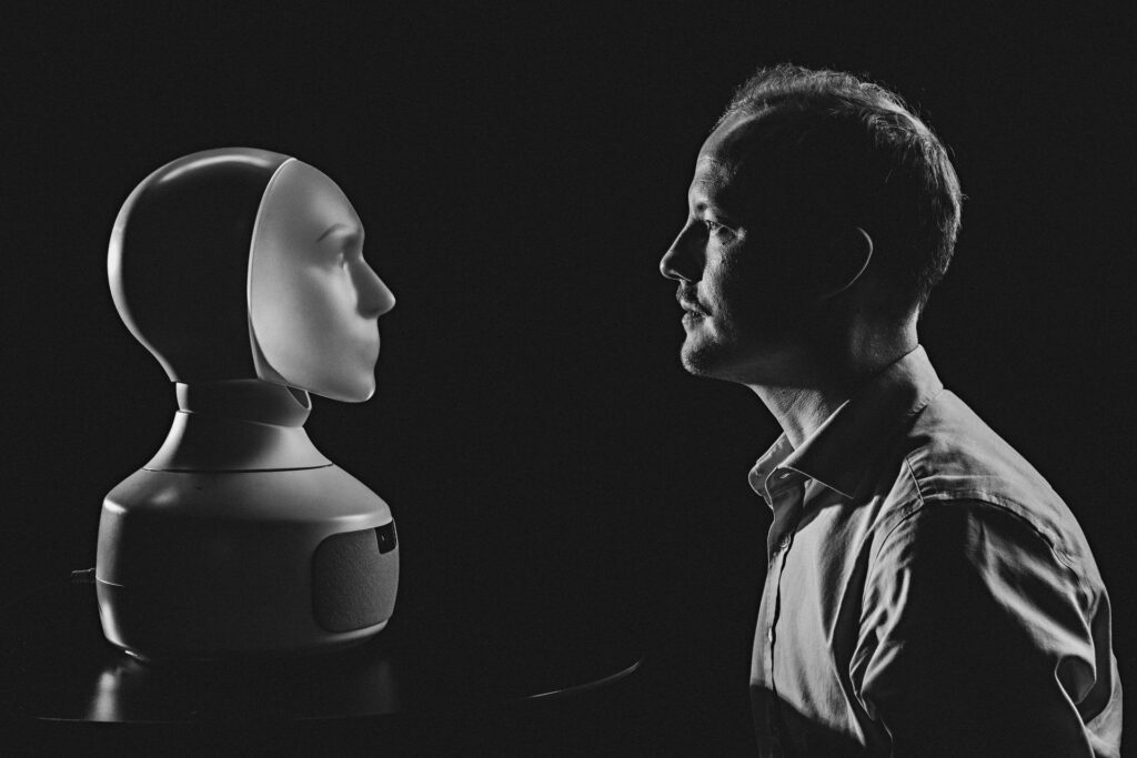 Mörk bild, en man och en robot. 